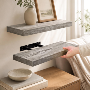 Wooden floating wall shelves styled with small plants, books, and neutral home decor in a bright living space.