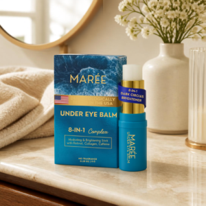 MAREE under eye balm stick displayed with skincare products on a neutral bathroom vanity.