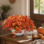 Artificial fall flowers arranged in a vase on a warm entryway table