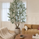 Tall artificial olive tree with planter styled in a warm living room